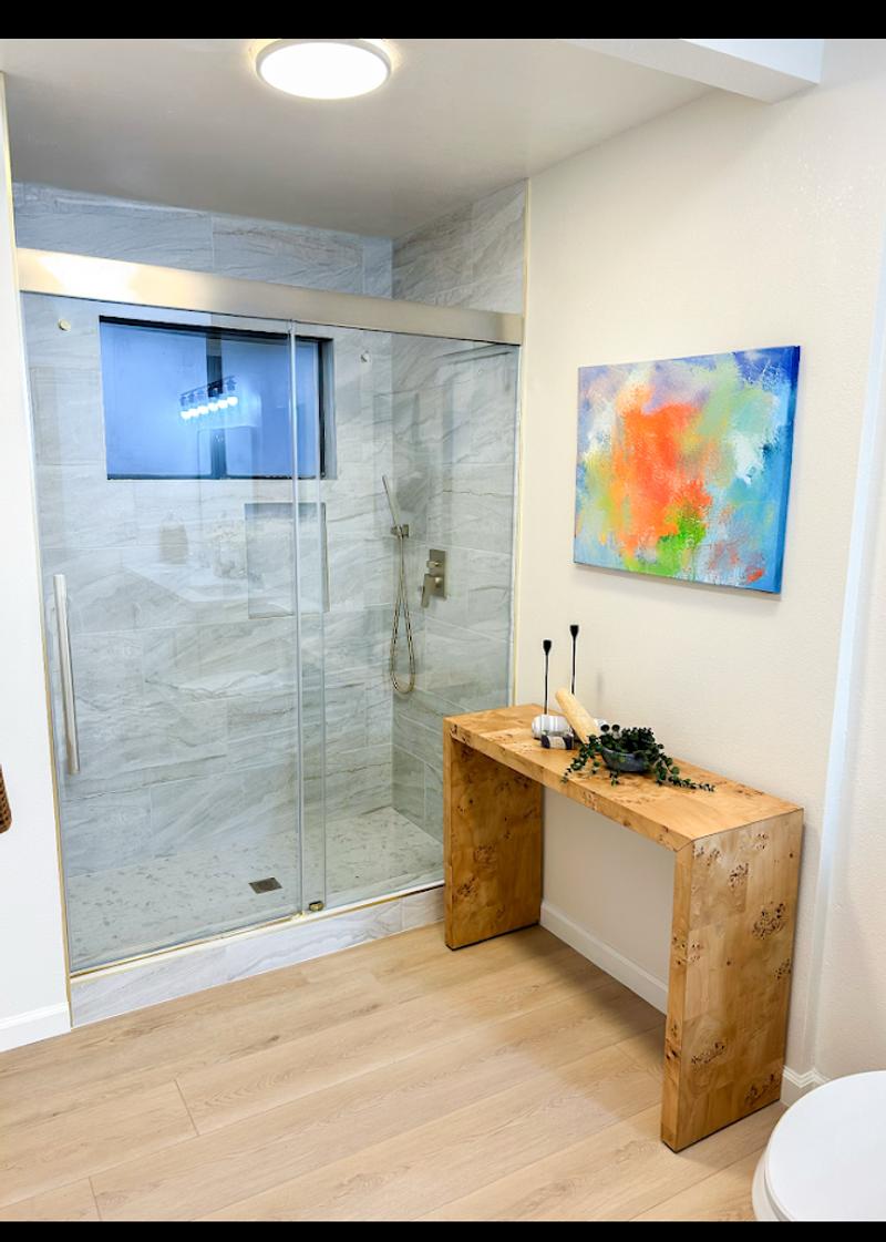Modern bathroom remodel featuring a frameless glass walk in shower, custom wood vanity, tile shower walls, and luxury bathroom finishes.