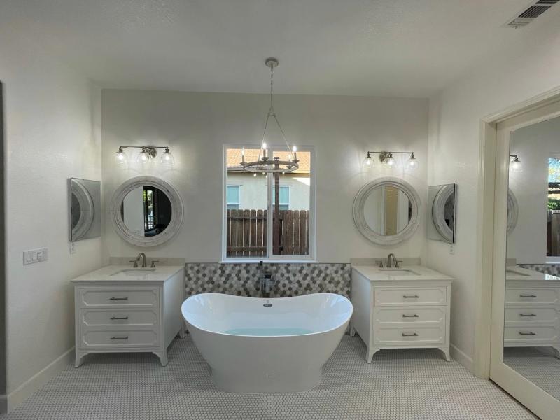 Bathtub refinishing near me with a modern freestanding tub, double vanities, and updated bathroom design in Roseville CA.